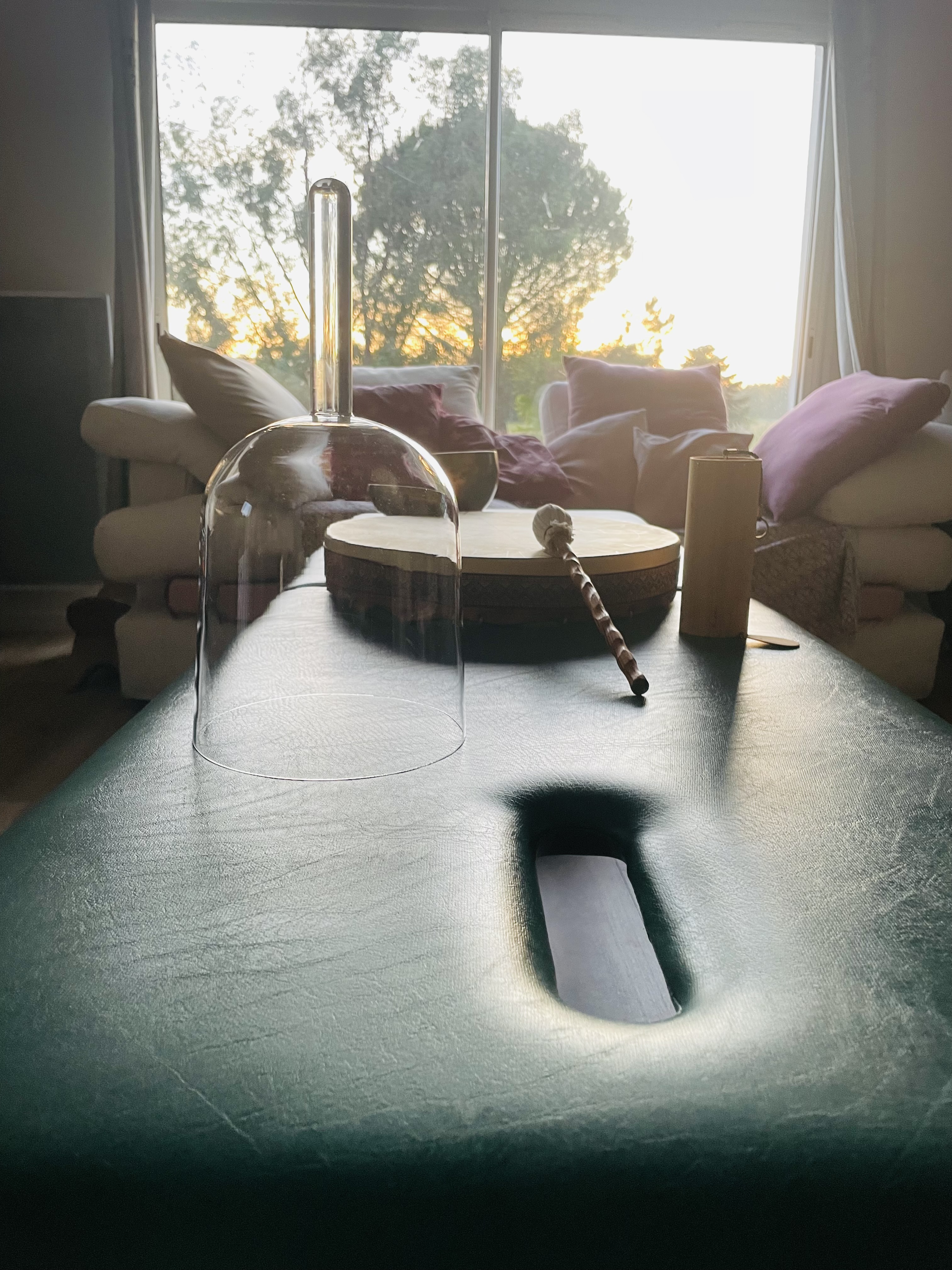 Bol de cristal chantant et tambour chamanique dans le cabinet d'Isabelle Chartier — coucher de soleil par la baie vitrée